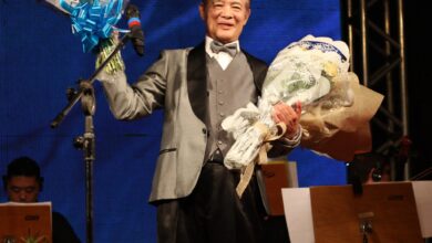 花束を手に笑顔を見せる北川名誉会長