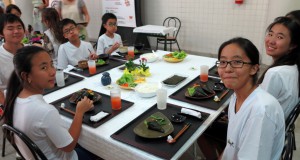 陶芸家の本間秀子さんが寄付した立派な陶器で食べる生徒たち