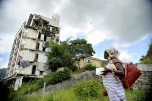 現存する大水で損壊した建物とそれを見つめる住民（Tânia Rêgo/Agência Brasil,11/01/2016）