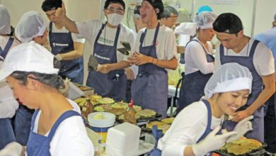 楽しそうにお好み焼きを焼く和歌山県人会の若者たち