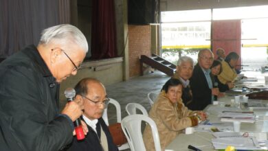 釈明を行う松尾治副会長（手前）とそれを聞く山村敏明聖南西連合会会長（奥から４番目）