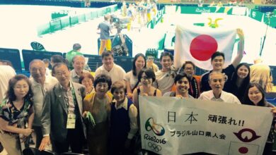 ９日、会場のリオ・セントロで河村衆議（左から３人目）と記念撮影に収まる山口県人会応援ツアー参加者（提供写真）