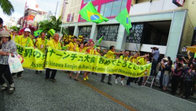 前夜祭パレードで、街道を練り歩くブラジル県人会関係者。呉屋春美文協会長、援協の与儀昭雄次期会長らも参加した（ウチナープレス提供）