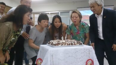 ろうそくの火を吹き消す呉屋春美会長（右から２人目）ら