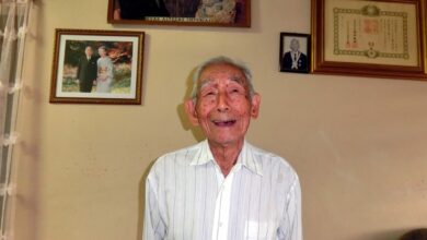 御真影を背景に安永忠邦さん