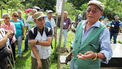 一行に日本人墓地の由来を説明する田辺さん