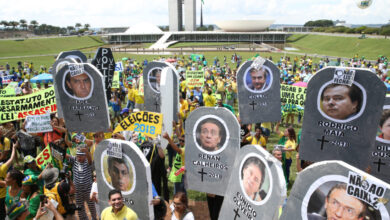 政治家や企業家の顔写真を掲げて、汚職反対デモを行う人々（Antonio Cruz/Agência Brasil）