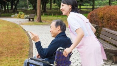 屋外の車椅子の男性と介護士（日本、フリー写真サイト「写真AC」より）