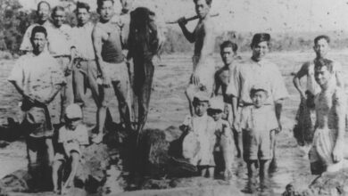 戦後、日本に帰国する人の送別会の様子。釣り上げた巨大魚で門出を祝った。魚の後ろに立つ面長の男性とその家族が帰国した