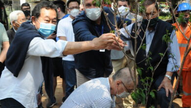 桜を植樹する野村市議（左）とサレス地区長（中央）、右が池崎会長